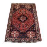 Middle Eastern wool rug, the indigo field with brick-red hexagonal medallion and central indigo