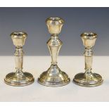 Three mid 20th Century silver candlesticks to include: a pair, the larger single example 14.5cm