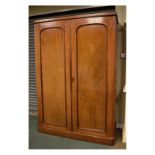 Victorian mahogany double wardrobe, the arch panel doors enclosing hanging space and base drawer