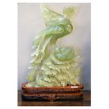 Chinese carved bowenite sculpture modelled as a mythical bird perched upon a bough, on a carved