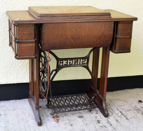 Oak cased Singer sewing machine with cast iron treadle base Condition: