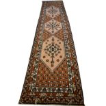 Middle Eastern style wool rug or runner, the rust coloured field with three pale pink hexagonal