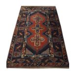 Middle Eastern wool rug, the crimson field with three cruciform medallions within multi borders,