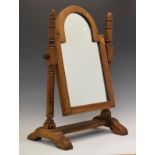 Reproduction oak swing dressing mirror with arched plate between turned uprights on platform base