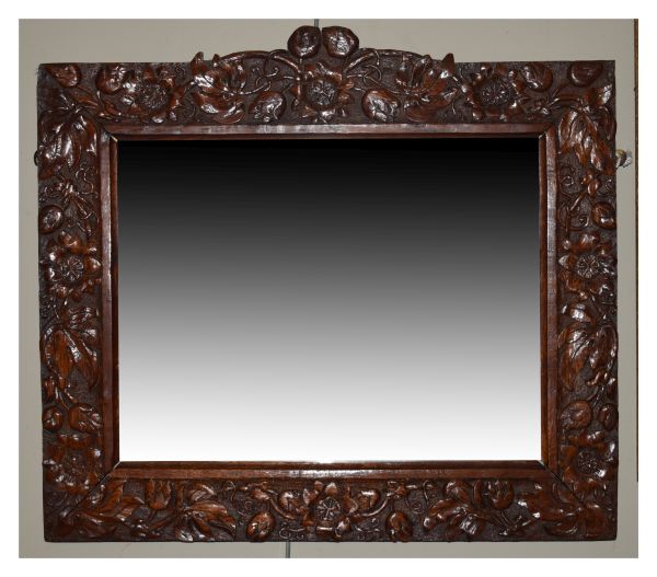 Late 19th/early 20th Century Arts & Crafts style carved oak wall mirror, the bevelled rectangular