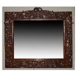 Late 19th/early 20th Century Arts & Crafts style carved oak wall mirror, the bevelled rectangular
