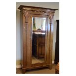 Early 20th Century carved oak Art Nouveau style wardrobe having bevelled rectangular mirror door