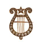 Early 20th Century lyre design seed pearl set brooch, the reverse stamped 18ct Condition: