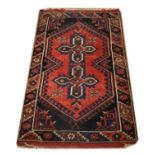 Wool rug having two geometric crosses against a red ground with multi border, 128cm x 74cm approx