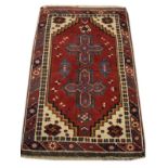 Wool rug having two geometric crosses against a red ground with multi border, 130cm x 78cm approx