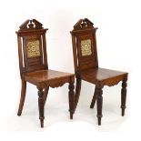 Pair of late 19th Century oak hall chairs having pediment cresting, the back inset with a brown