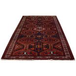 Mid 20th Century red ground rug having geometric lozenges and multi border, 160cm x 250cm approx