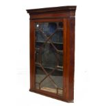 George III mahogany corner cupboard having a dentil cornice over thirteen pane astragal glazed