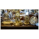 Three assorted mid to late 20th Century anniversary or torsion clocks, together with a day/date desk