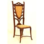Early 20th Century stained beech or walnut high-back occasional chair, the leaf carved top rail over