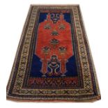 Mid 20th Century wool rug with central red panel against a blue background with multi border, 2m x