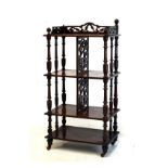 Victorian walnut four tier étagère having fret work divisions and turned supports, 108cm tall