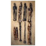 Group of nine African carved hardwood figures to include a pair of water carriers, old man holding a