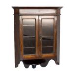 Early 20th Century fruitwood wall hanging corner cabinet with glazed doors enclosing adjustable