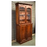 19th Century mahogany bookcase on cabinet, the upper section with arch-glazed twin doors enclosing