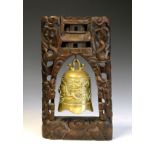 20th Century Chinese carved hardwood and brass table bell, the brass bell cast in relief with a