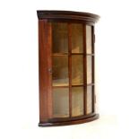 Early 20th Century mahogany bow front corner cabinet with nine-pane glazed door enclosing shelves