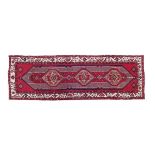 Good quality modern Persian or Turkish runner decorated with three geometric medallions on a red