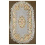 Indian oval wool rug having typical floral decoration on a pale blue ground Condition:
