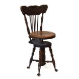Late Victorian revolving music seat, the crest rail with carved decoration and supported by turned