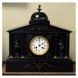 Victorian black slate architectural style mantel clock having spelter figural decoration depicting
