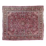 Modern Middle Eastern wool rug having allover stylised foliate decoration on a red ground within