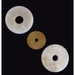 Three Chinese hardstone archaic style bi discs, 3.5cm and 5cm diameter Condition: No obvious