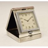 George V engine turned silver cased travel alarm clock, the off-white dial with Arabic numerals,