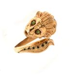 Enamelled lion ring, stamped '750', the roaring lion's head with green cabochon eyes, green enamel