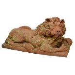 Garden Statuary - Large moulded terracotta model of a recumbent lion on integral rectangular base,