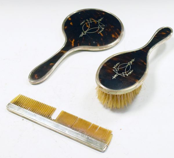 George V silver and tortoiseshell three piece brush set comprising: hand mirror, brush and comb,