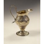 George III silver baluster shaped cream jug having engraved foliate decoration, high loop handle and