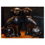 Pair of early 20th Century Staffordshire terracotta 'comforter spaniels', each with black glaze