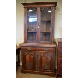 Early 20th Century walnut bookcase on cabinet, the upper stage having a pair of arch-glazed doors