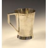 George VI silver mug having an angled handle and standing on a circular flared foot, Sheffield 1945,