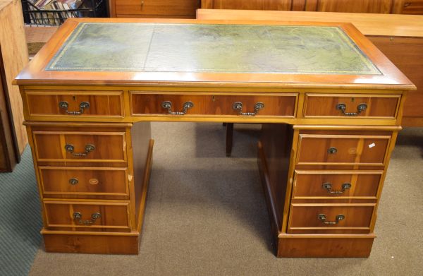 Reproduction yew-wood twin pedestal office desk having a gilt-tooled green skiver over three