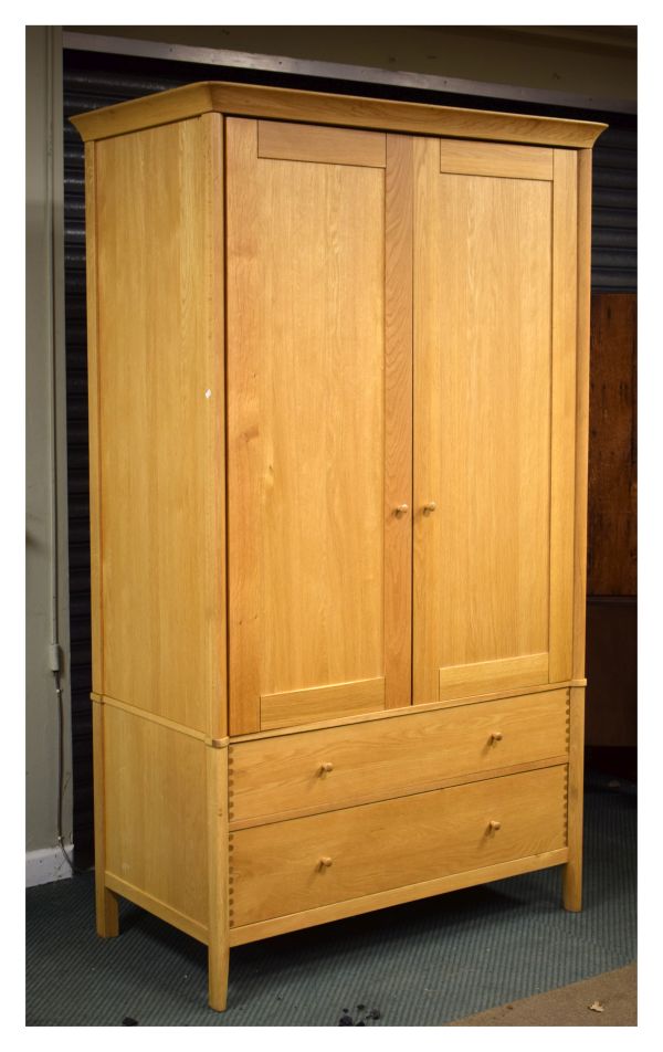 Modern light oak wardrobe, the upper section fitted two panelled doors with two drawers below