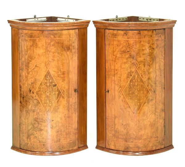 Pair of 20th Century walnut and marquetry bowfront hanging corner cupboards, each with foliate