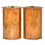 Pair of 20th Century walnut and marquetry bowfront hanging corner cupboards, each with foliate