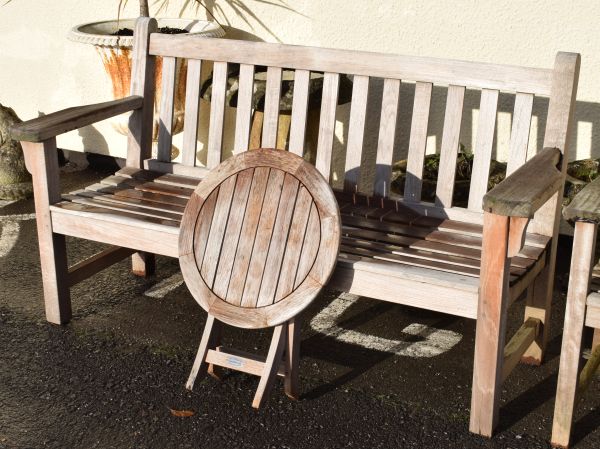 Slatted hardwood garden bench with broad arms, together with a Bramblecrest teak circular folding