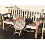 Slatted hardwood garden bench with broad arms, together with a Bramblecrest teak circular folding