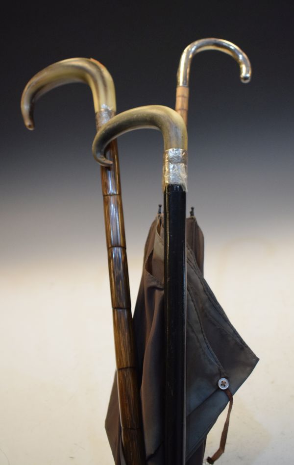 Two silver-mounted horn-handled walking canes or sticks, together with a silver-handled umbrella