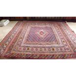 A Middle Eastern red ground rug with 5 b