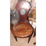 An antique hall chair with stylised roun