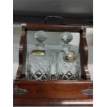 An oak Tantalus with two glass decanters.